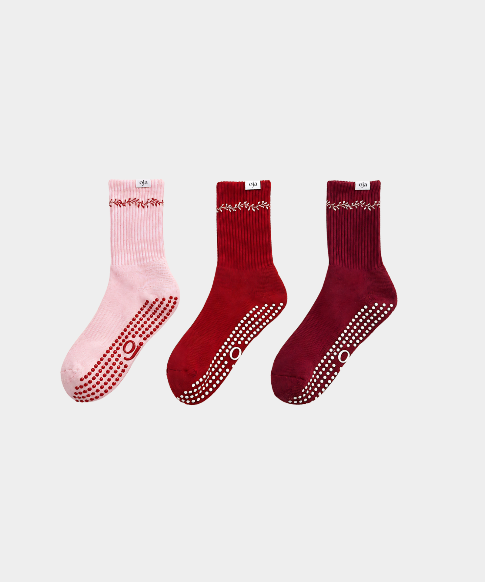 Three pairs of socks in pink, red, and burgundy on a light gray background