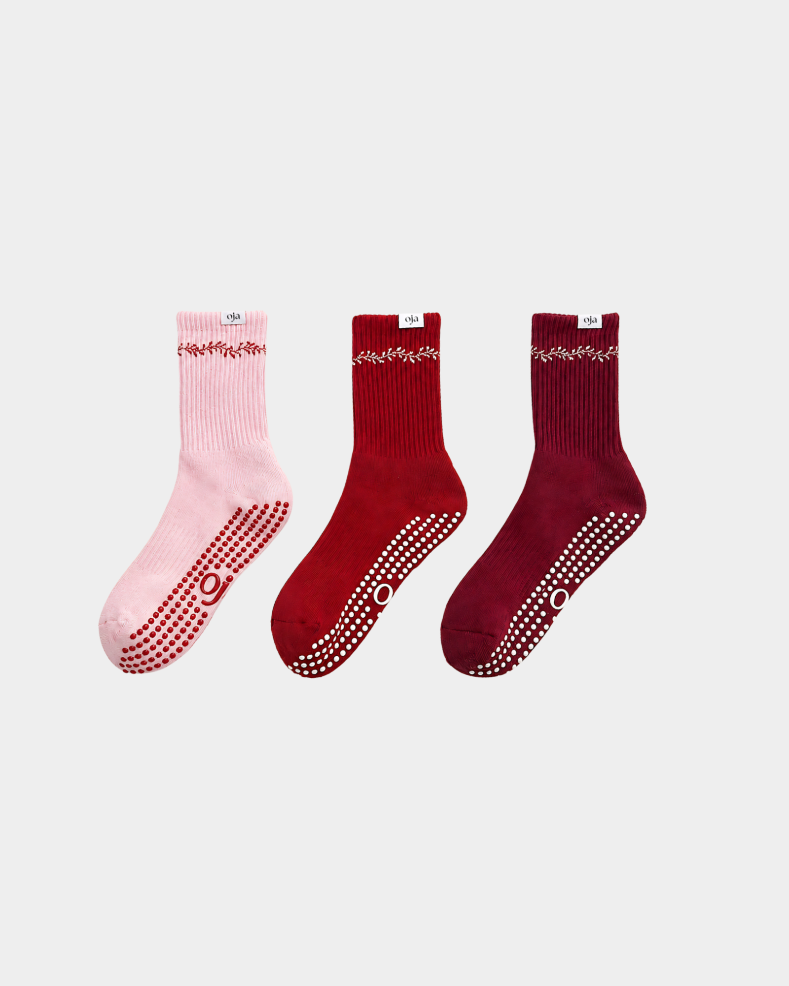 Three pairs of socks in pink, red, and burgundy on a light gray background