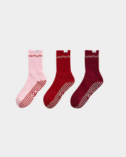 Three pairs of socks in pink, red, and burgundy on a light gray background