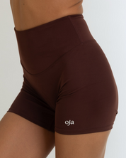 Zoom view of Espresso Color Ease Form Shorts From with Silicone White Logo, OJA Wear Philippines - Activewear & Athleisure for Pilates and Workouts